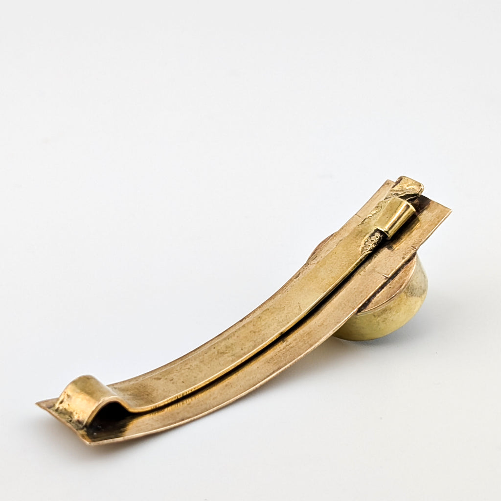 Gold hair clip on a light gray background