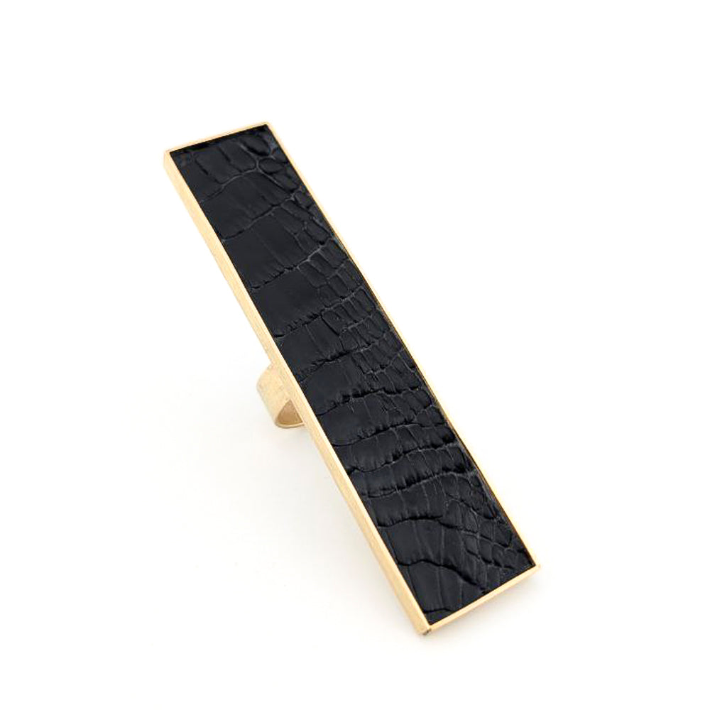 Brass rectangular ring with black caiman leather embedded inside against a white background.