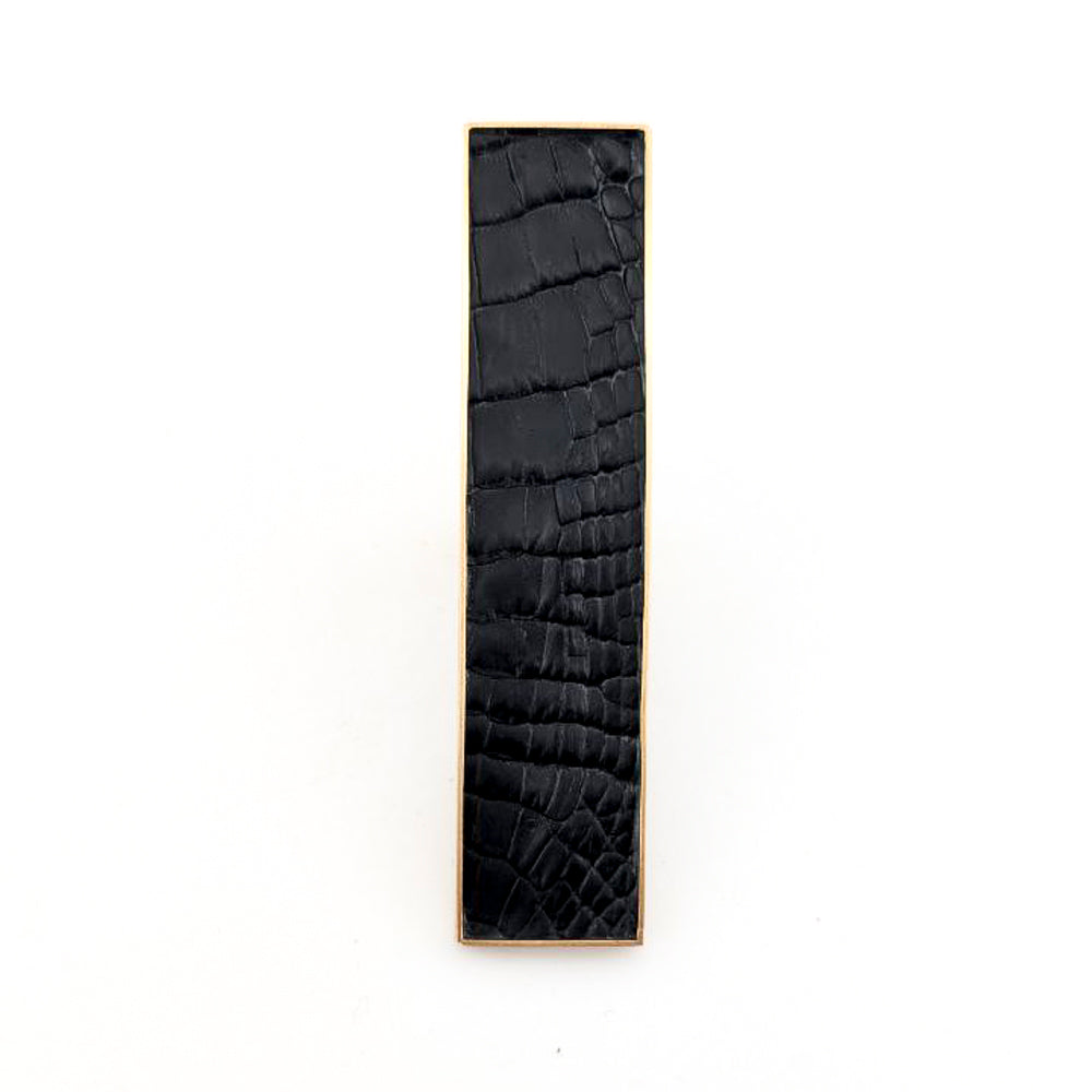 Brass rectangular ring with black caiman leather embedded inside against a white background.