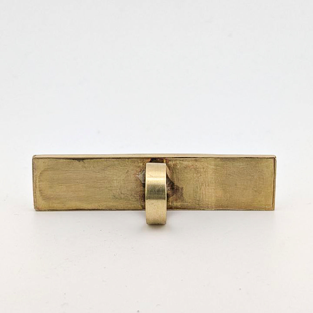 Brass rectangular ring against a white background.