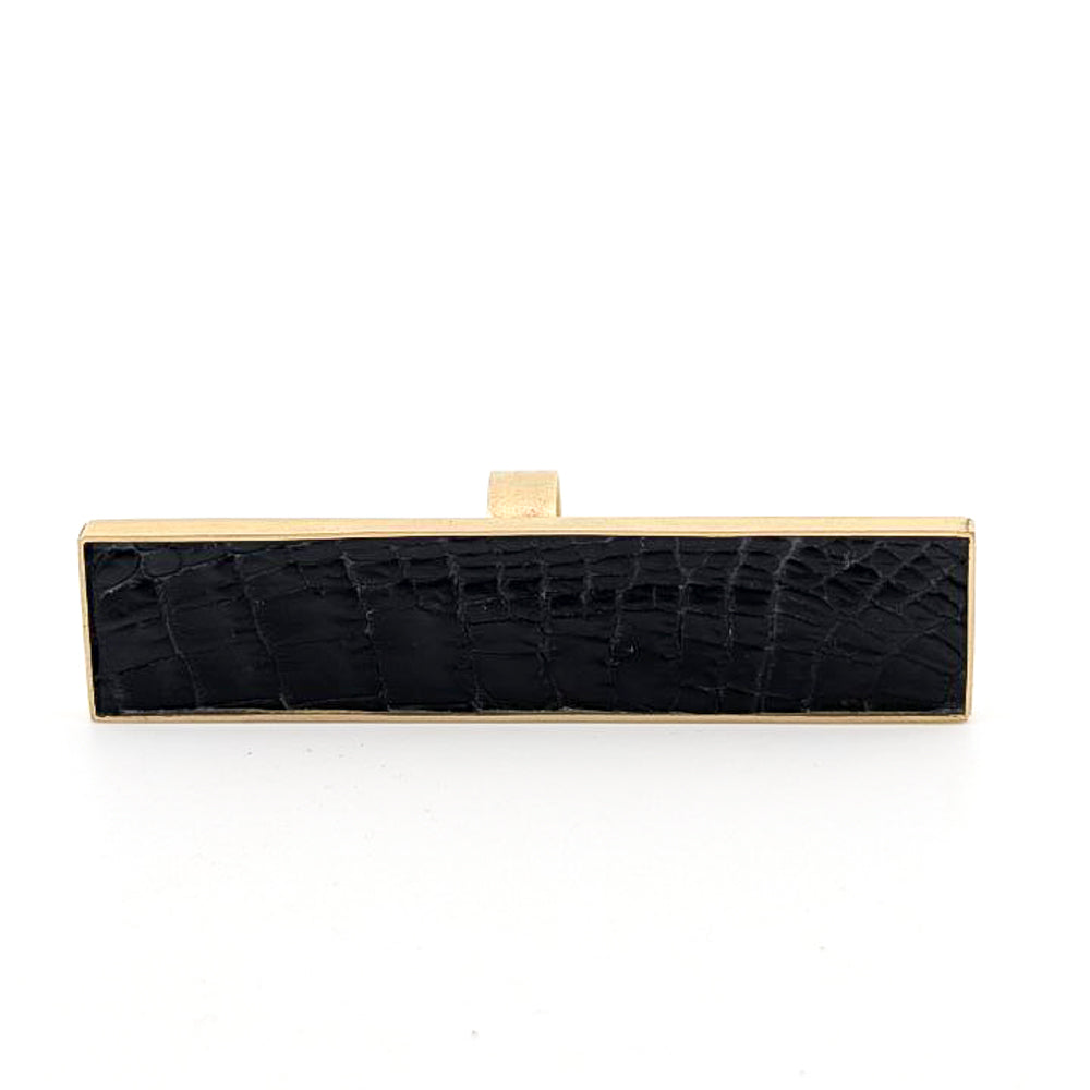 Brass rectangular ring with black caiman leather embedded inside against a white background.