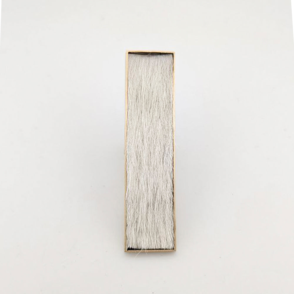 Brass rectangular ring with white cowhide embedded inside against a white background.