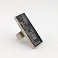 Silver ring with black snakeskin design on a white background