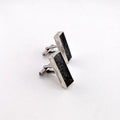 Pair of silver and black rectangular cufflinks on a white background